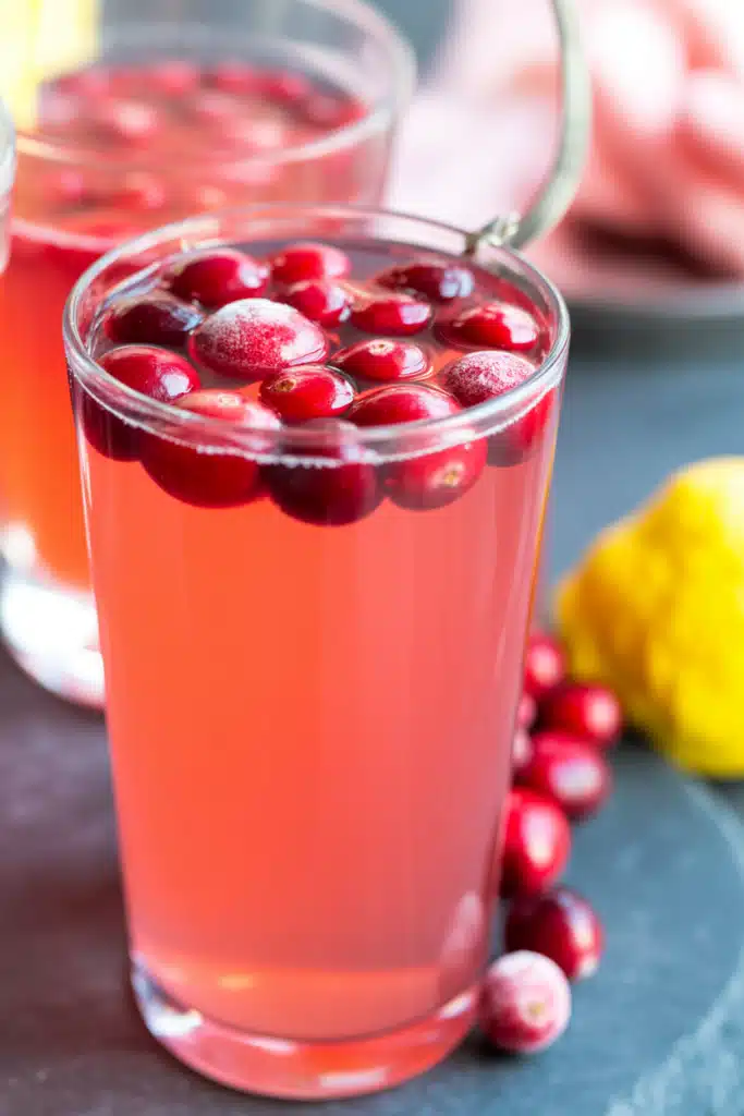 Close-up glass of cranberry lemonade with lemon slice and cranberries