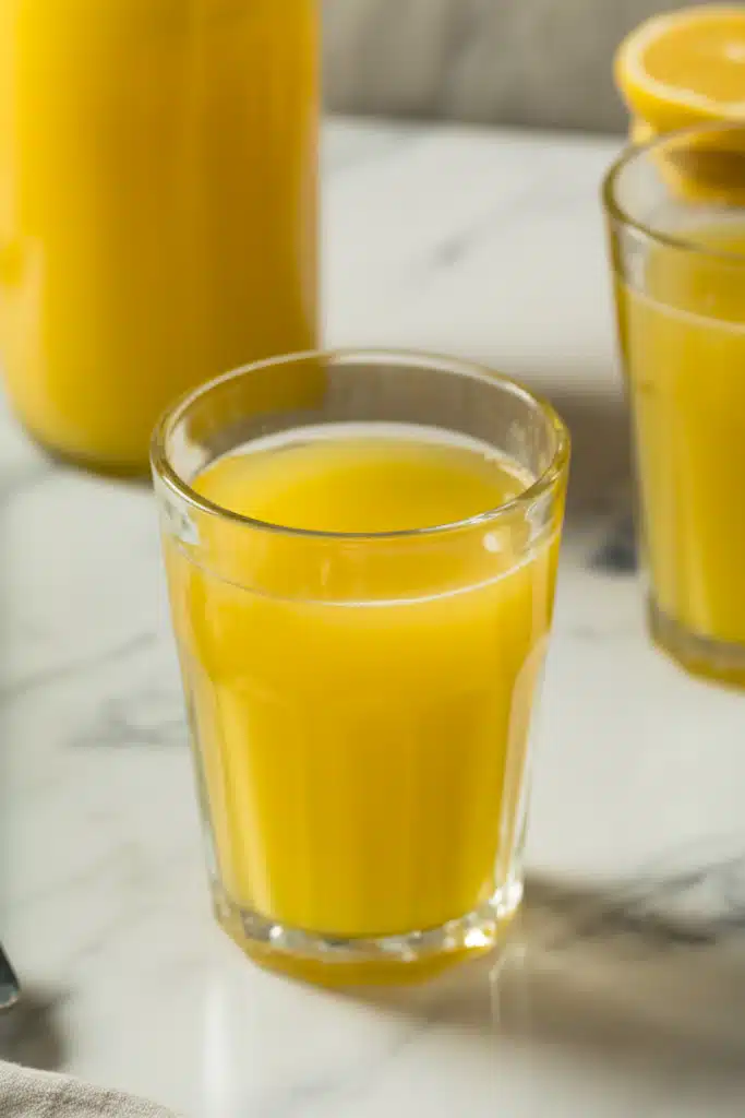 Orange lemonade in glass with citrus slices and mint