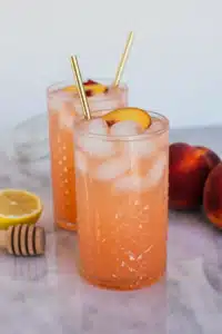 Peach lemonade with peach slices, lemon wheels, and mint