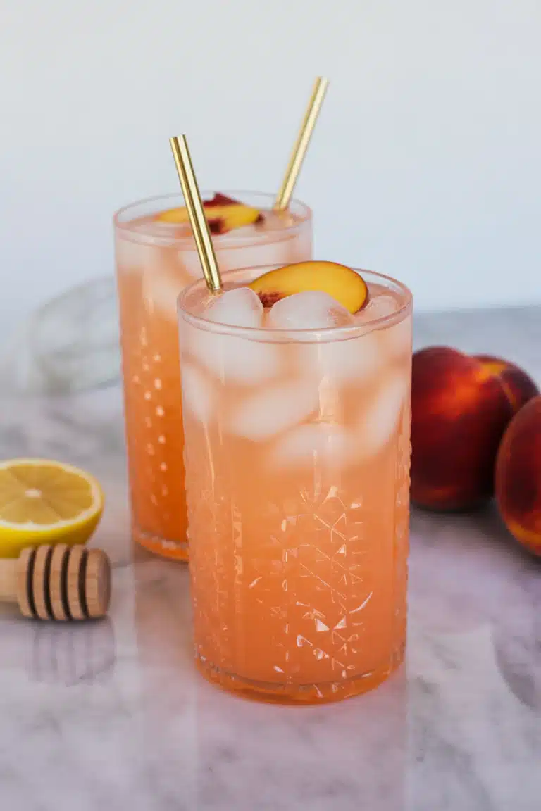 Peach lemonade with peach slices, lemon wheels, and mint