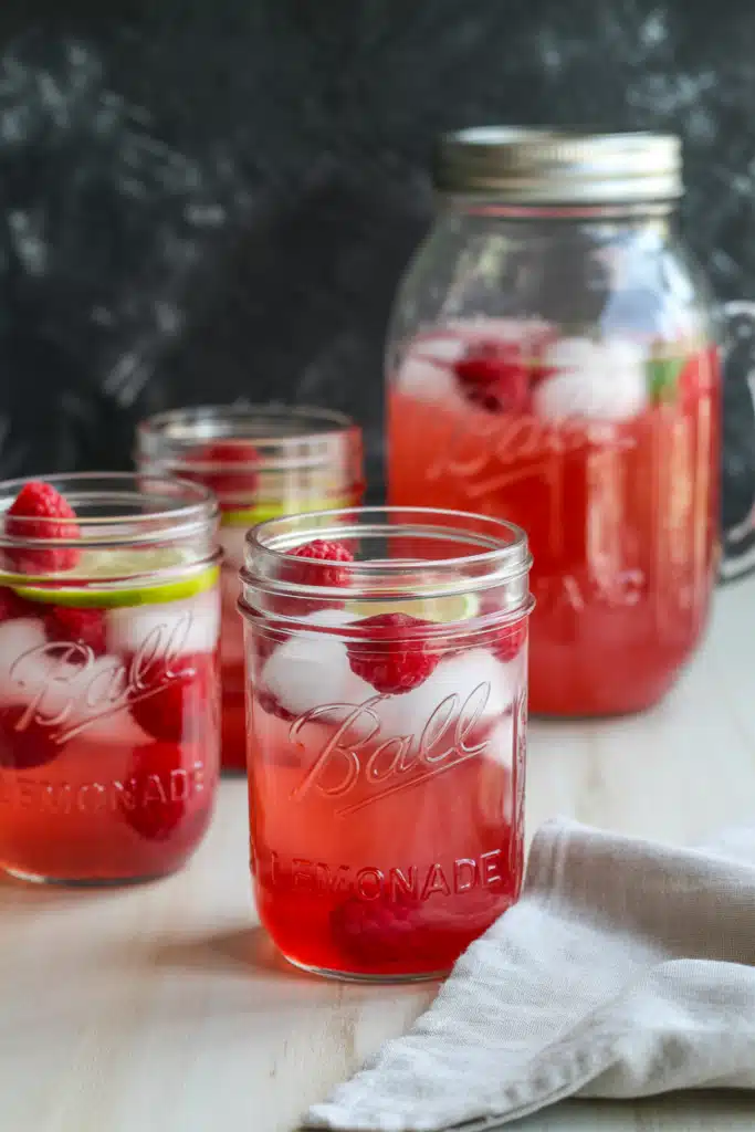 Close-up raspberry lemonade with lemon slice, raspberries, and mint